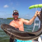 Captain Brian Sawyer holding up a cobia he caught.